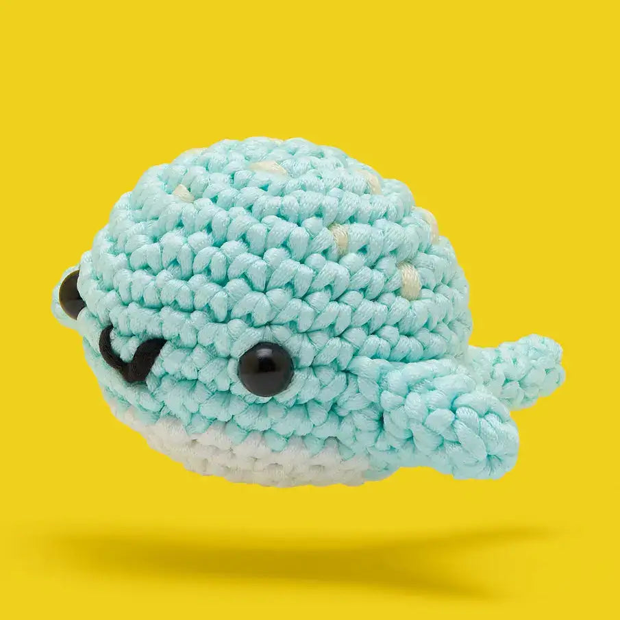 Beginner Colorful crochet dog on a green background crochet kit with yarn, hook, and stuffing